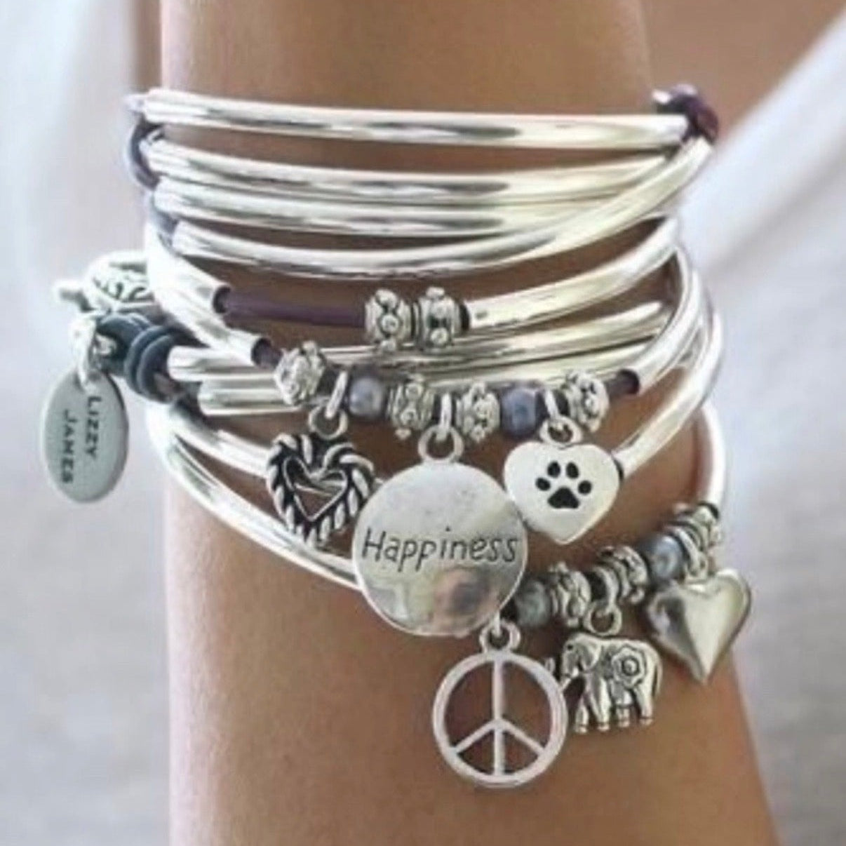 Leather wrap bracelet with silver crescent beads and assorted charms on womans wrist