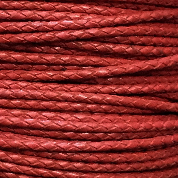 A close-up of red braided cord or rope filling the frame, showing the woven texture in horizontal strands.