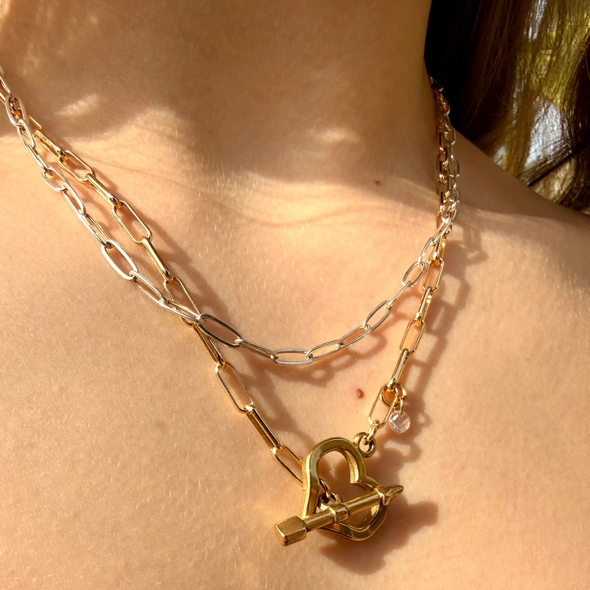 Gold necklace with a unique pendant on a person's neck