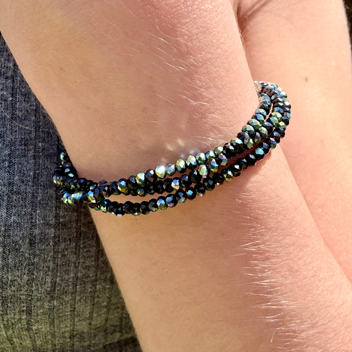 Multistrand beaded bracelet on a wrist with a denim background