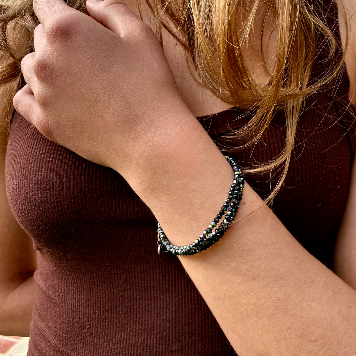 Close-up of a person wearing a beaded bracelet on their wrist.