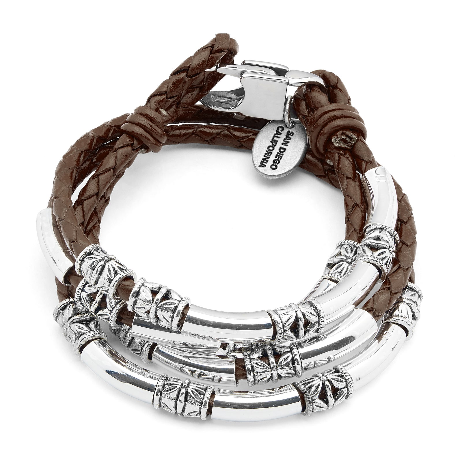 Close-up of a wrist wearing multiple silver bracelets with a blurred background