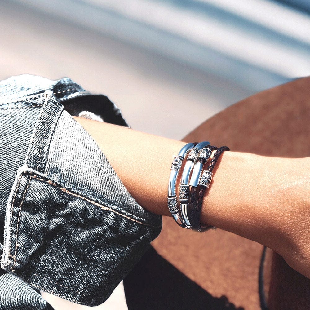 Close-up of a wrist wearing multiple bracelets with a blurred background