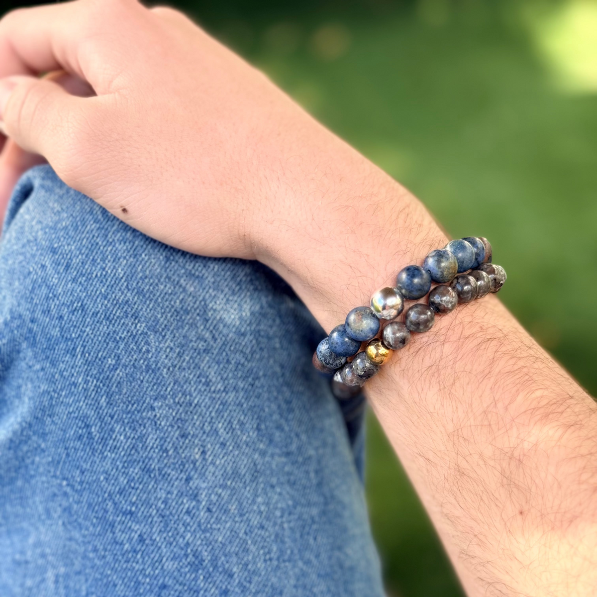 Person wearing a beaded bracelet on a blurred natural background