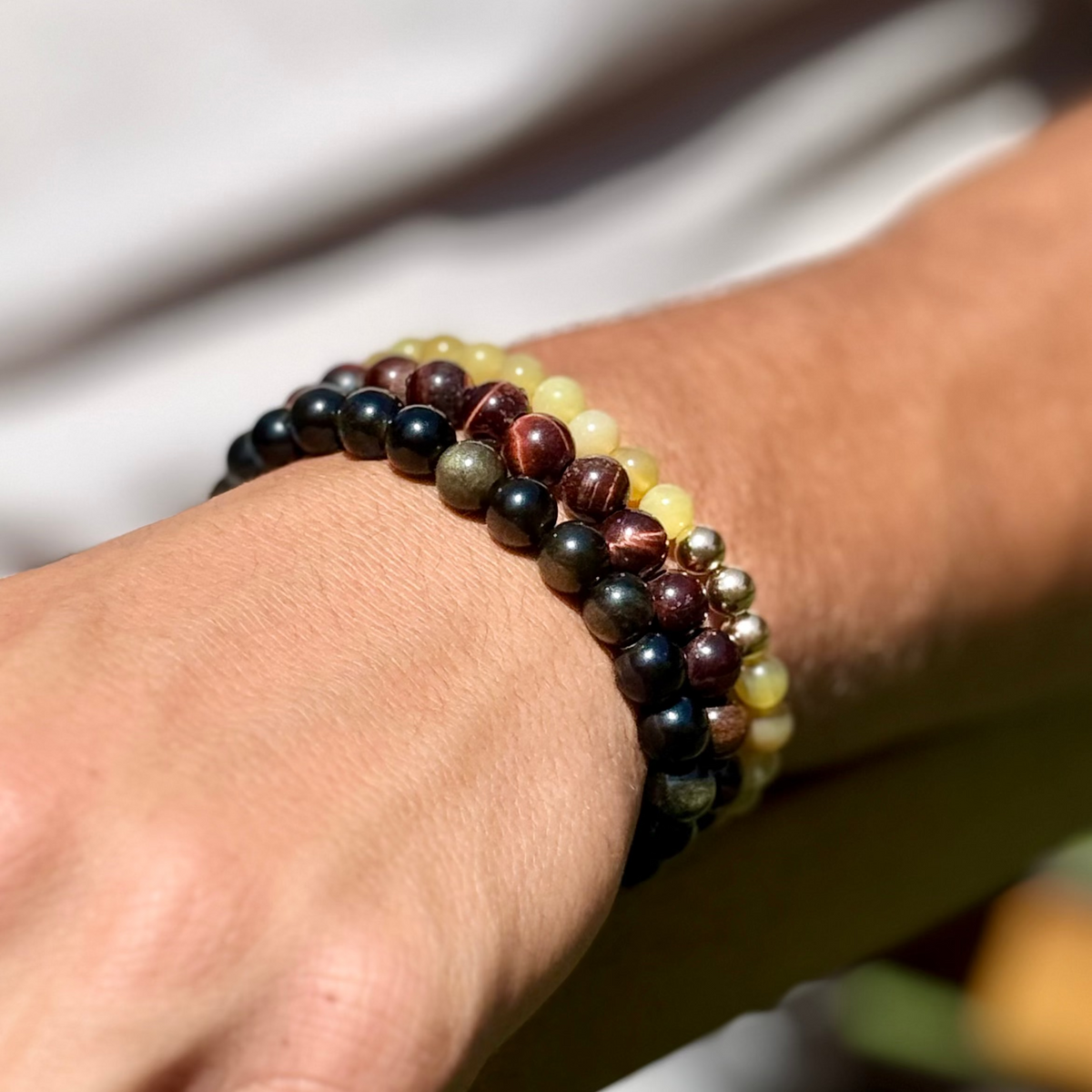 Close-up of a wrist wearing a beaded bracelet with a blurred background