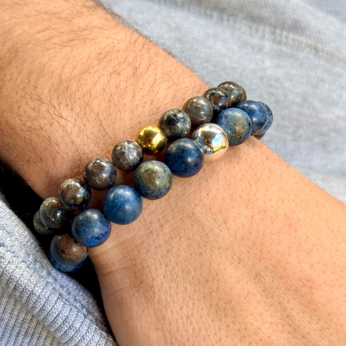 Close-up of a wrist wearing a blue beaded bracelet with gold accents.