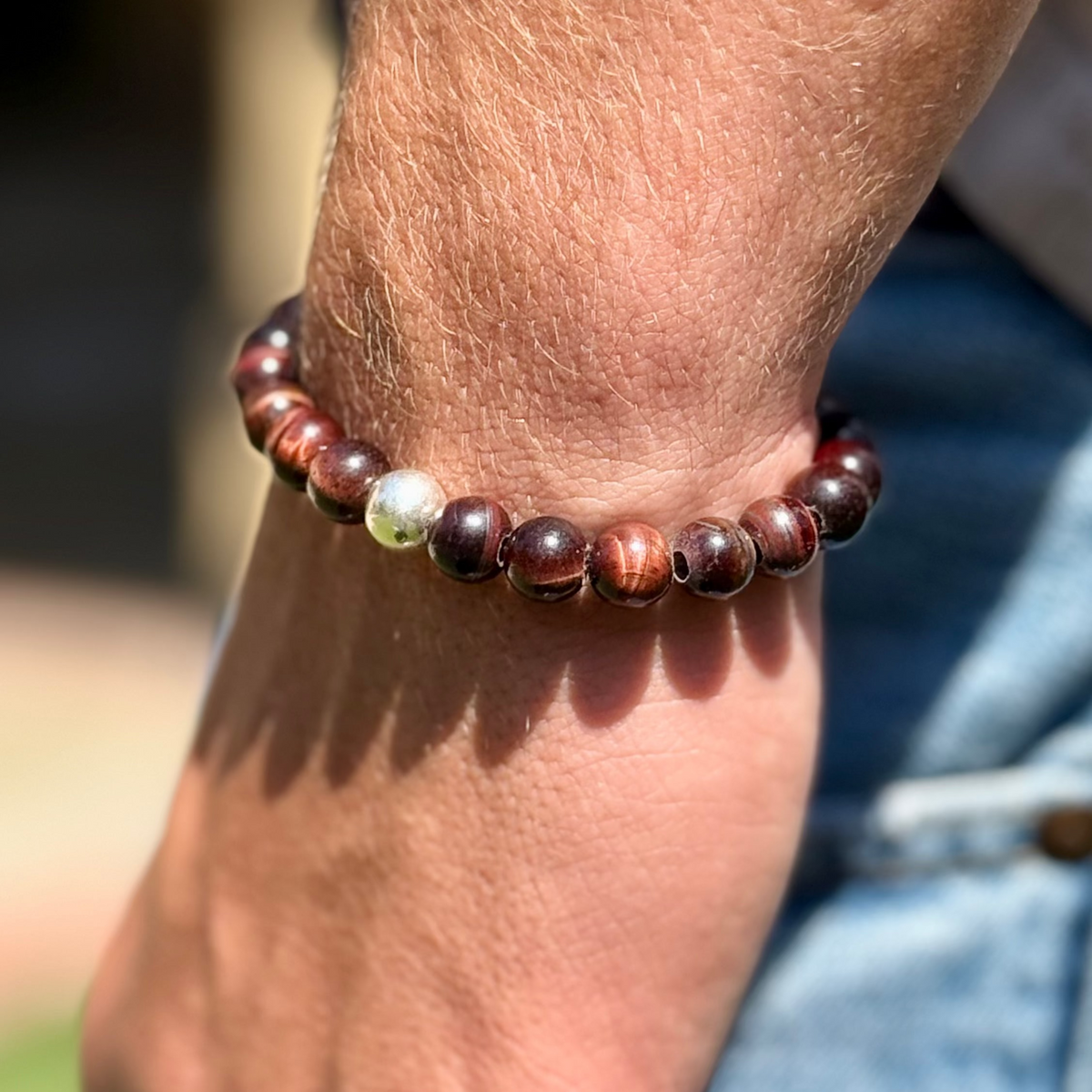 Close-up of a wrist wearing a beaded bracelet with a blurred background