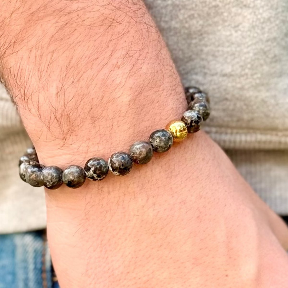 Close-up of a wrist wearing a beaded bracelet with a gold accent.