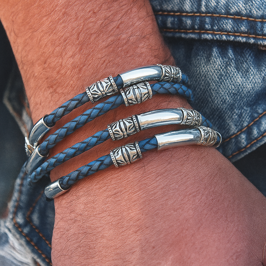 Blue braided leather bracelet with silver beads on a wrist, wearing denim jeans.