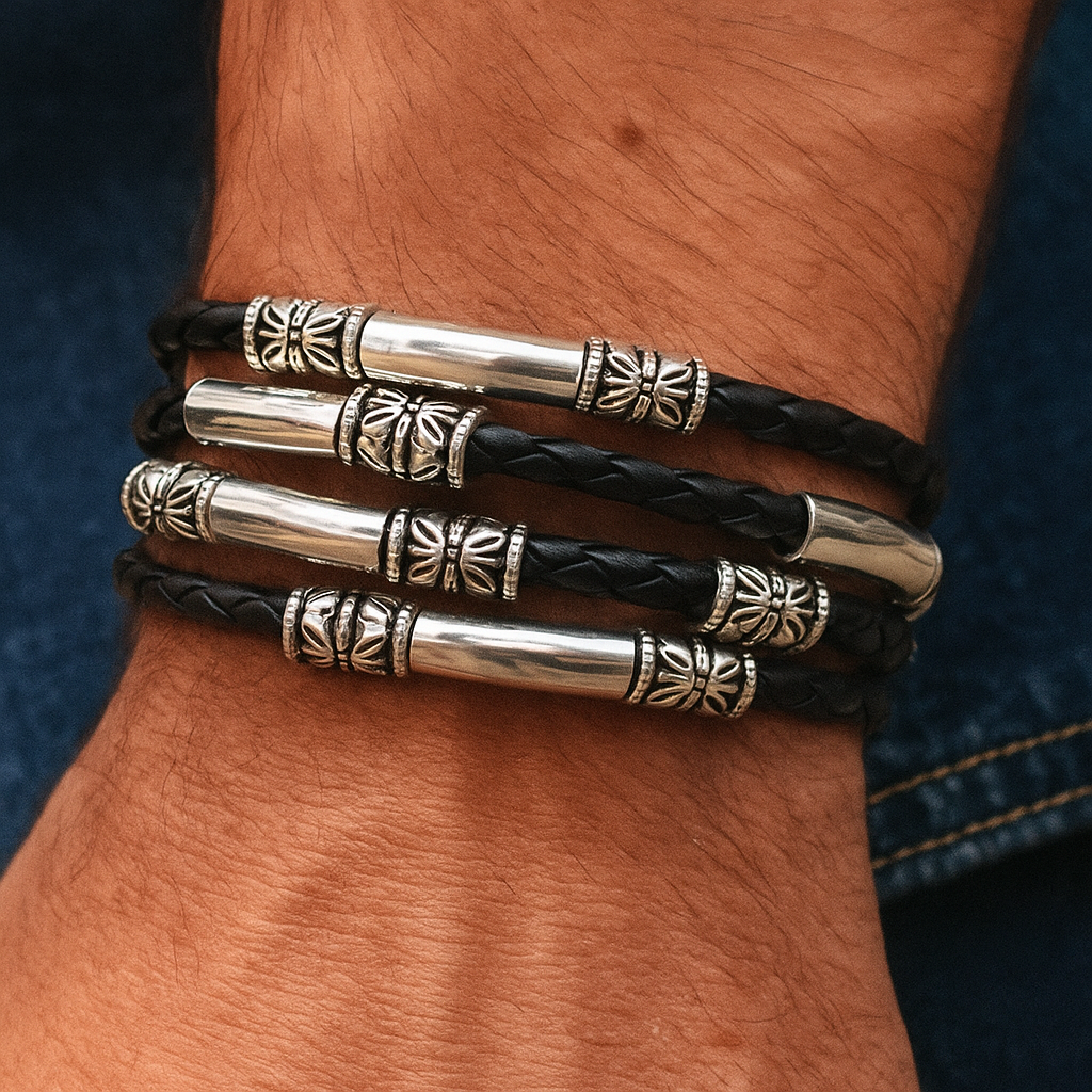 Close-up of a wrist wearing two black leather bracelets with silver cylindrical beads.