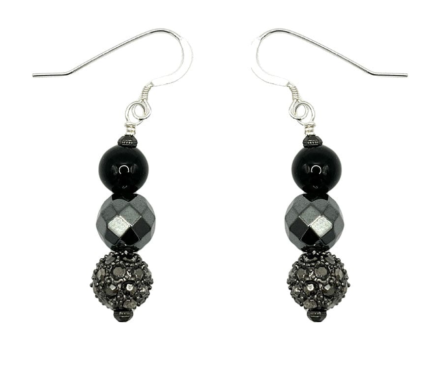Close-up of an ear wearing a black beaded earring with sunglasses on.