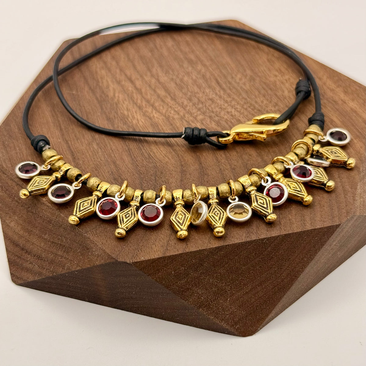 Gold and red beaded necklace on a wooden stand