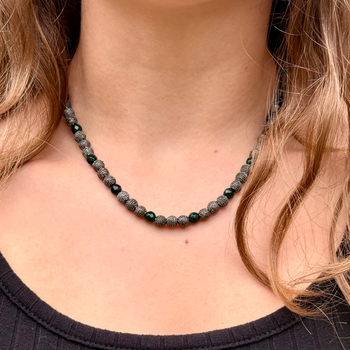 Woman wearing Noa emerald green jade necklace with gunmetal beads and mixed-metal jewelry