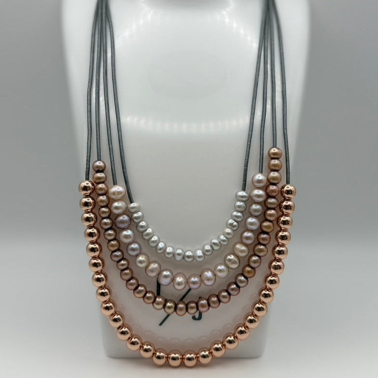 Necklace with pearls and rose gold beads on a mannequin bust.