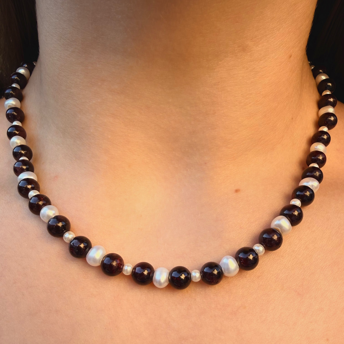 Necklace with black and white beads on a person's neck