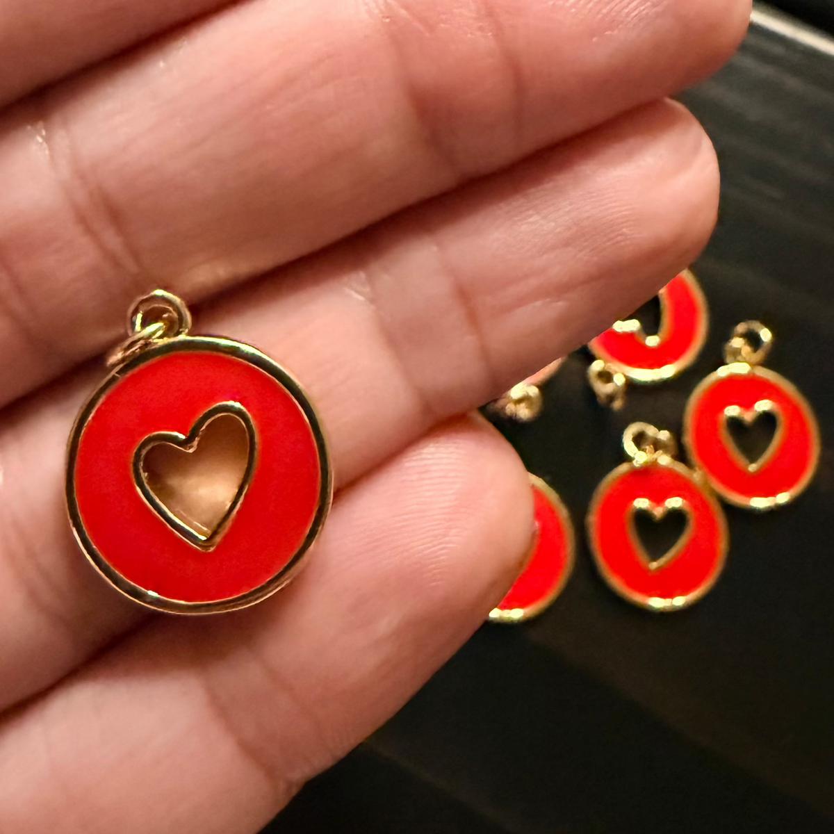 Dainty 18k gold-plated satellite chain necklace featuring a circular red enamel charm with a gold heart in the center.