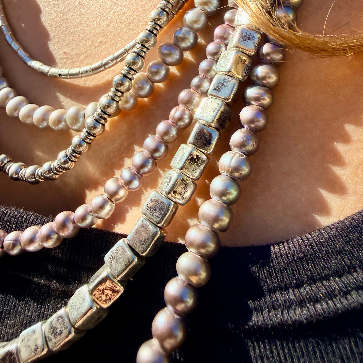 Women's 6-strand bib statement necklace featuring purple metallic leather, silver and purple pearls, and silver beads with a secure potato clasp.