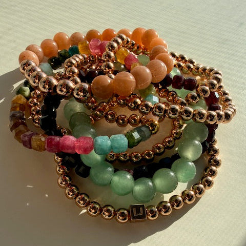 Stack of colorful beaded bracelets on a light background