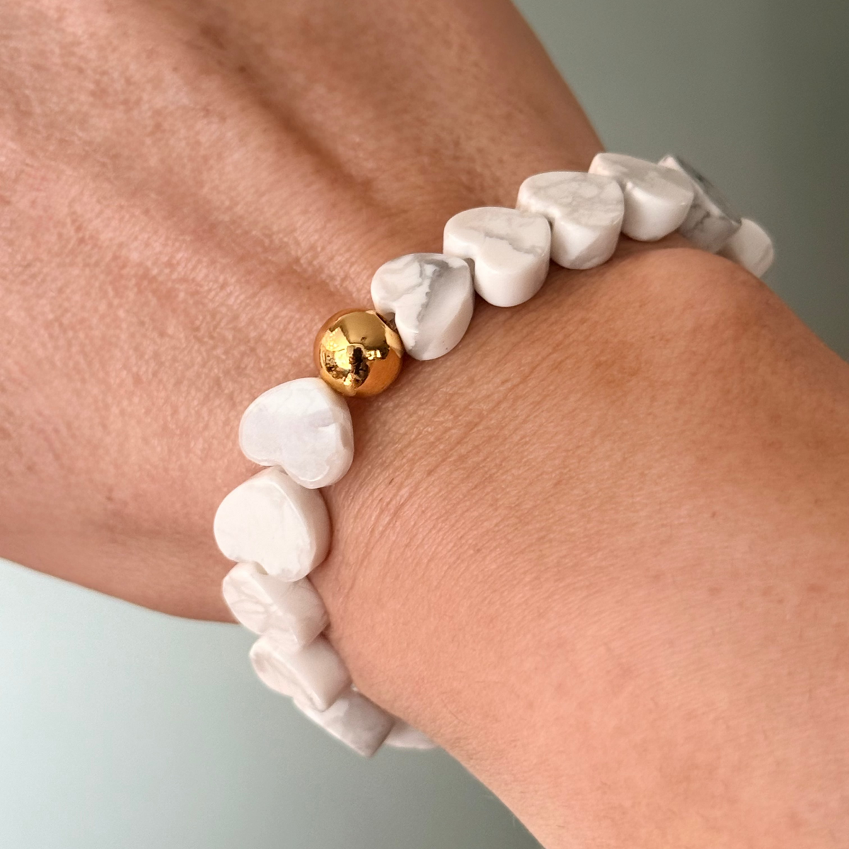 Howlite Heart Stretch-to-Fit Bracelet with one gold accent bead on womans wrist