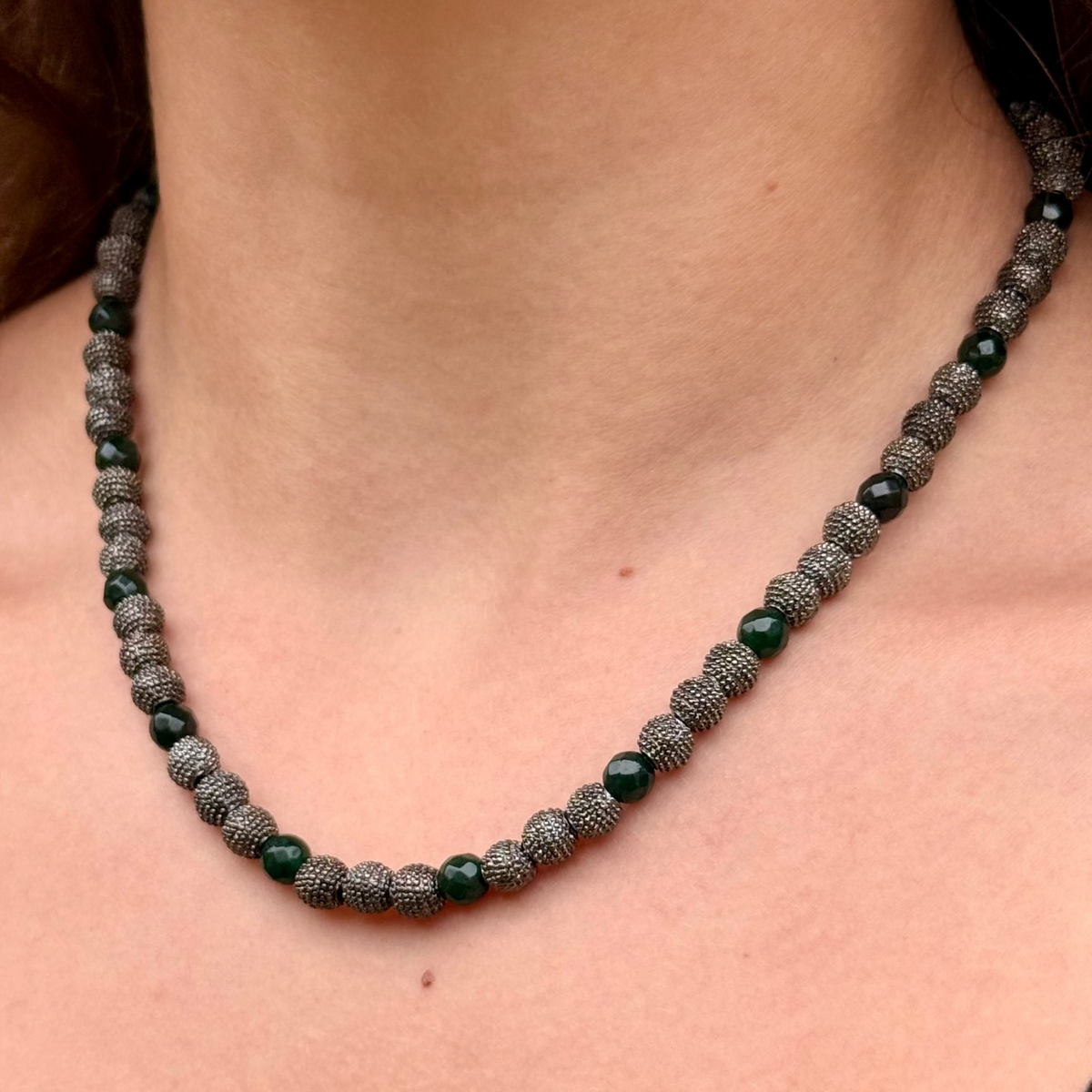 Woman wearing Noa emerald green jade necklace with gunmetal beads and mixed-metal jewelry