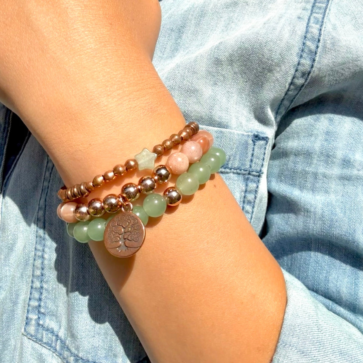 Stack of beaded bracelets on a wrist with a denim background