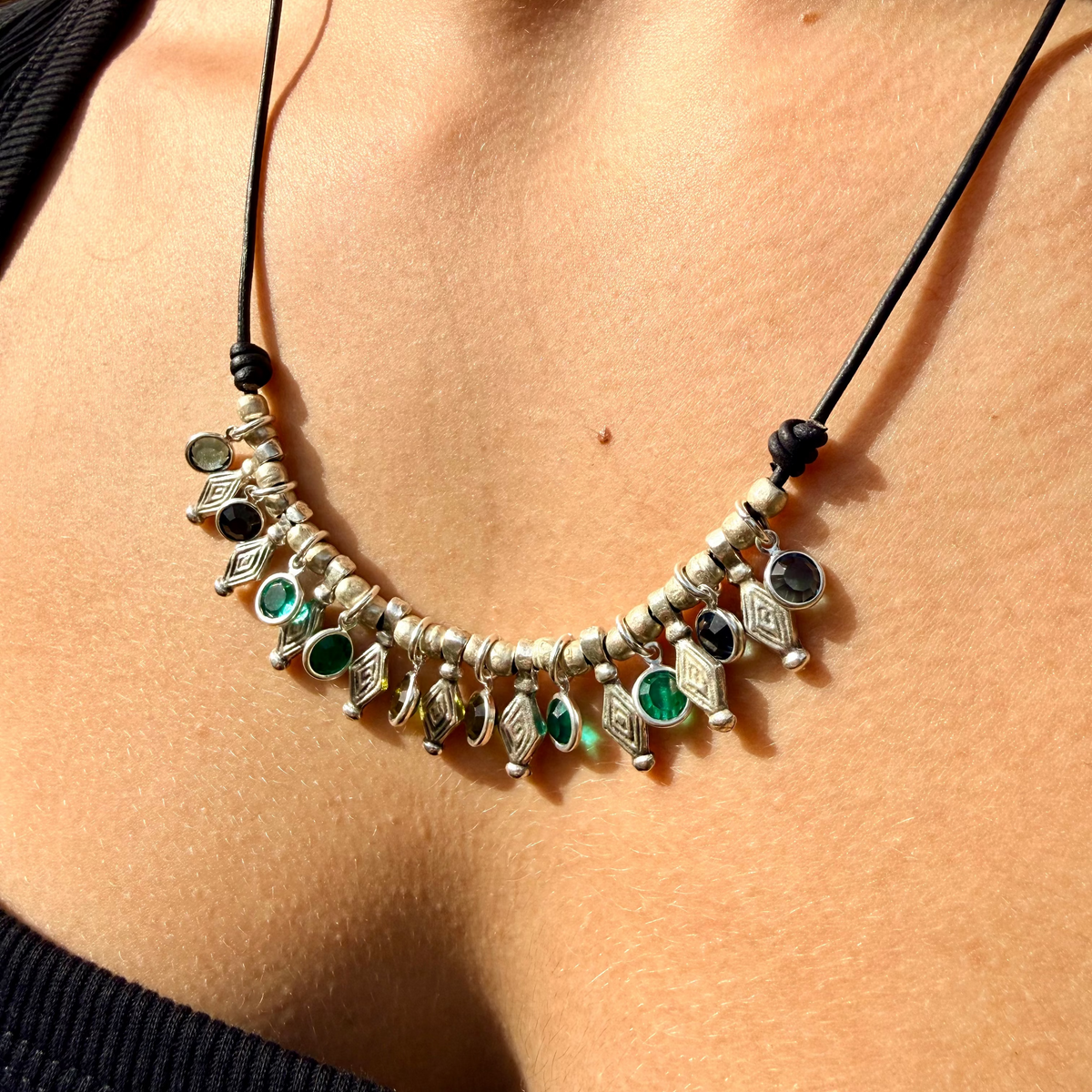 Necklace with beads and stones worn by a person