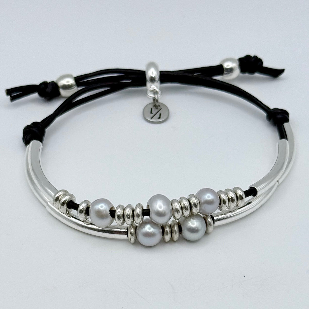 Bracelet with pearls and silver accents on a light gray background