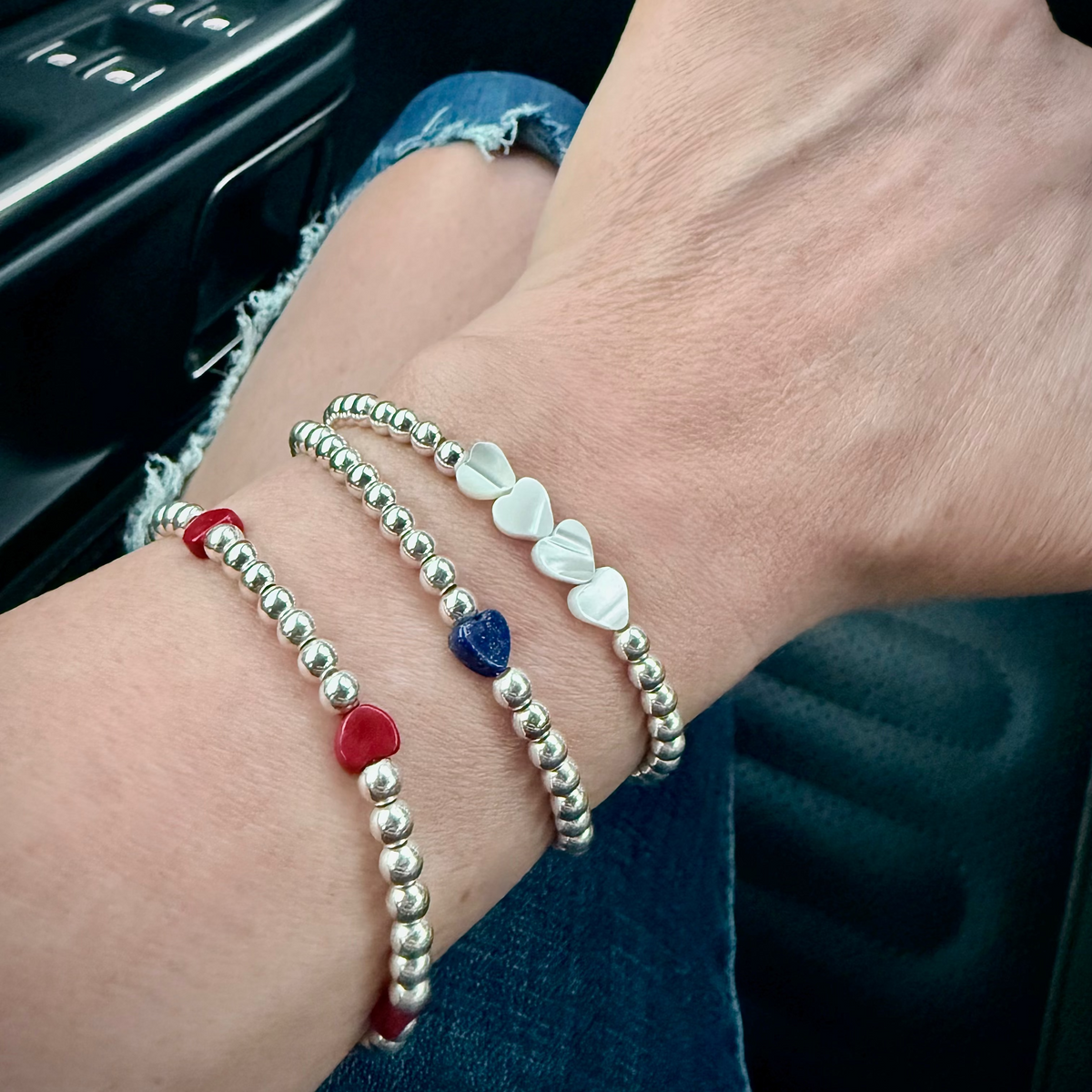 Close-up of a wrist wearing multiple bracelets with a blurred background