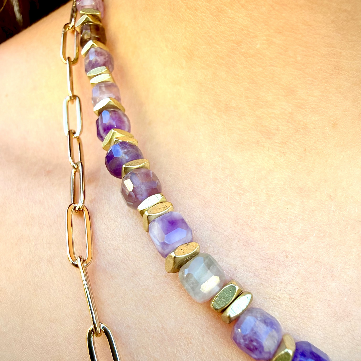 Necklace with purple and gold beads on a person's neck