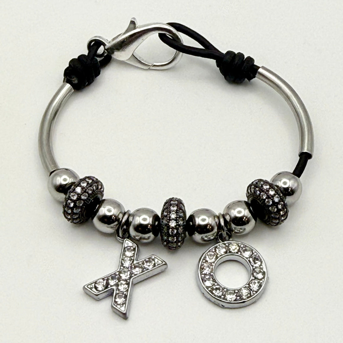 Women's black leather bracelet with silver XO charms, silver-tone beads, and pavé crystal accents.