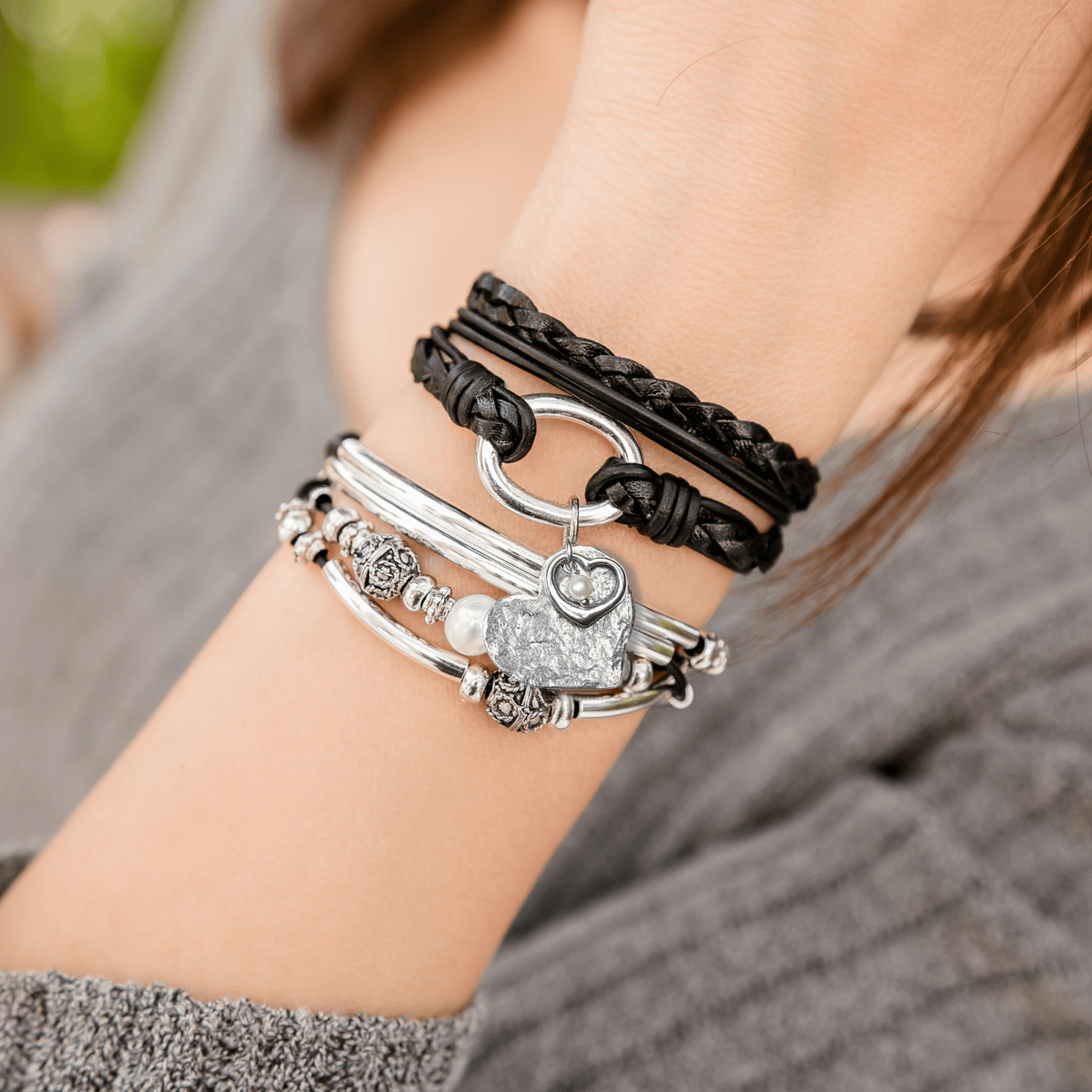 Paisley Braided Black Leather Wrap Bracelet with Silver Ring shown with the Silver Endless Love heart charm trio stacked next to the Holly wrap bracelet with pearl