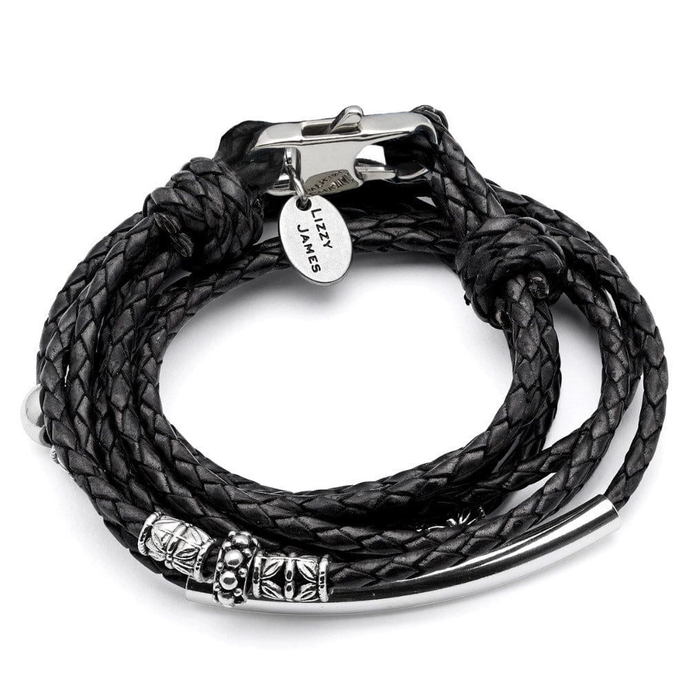 Close-up of a person's wrist wearing a black braided leather bracelet with silver metal elements.