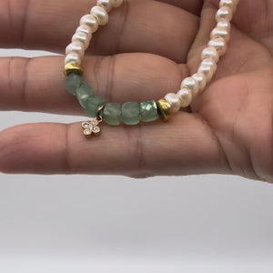 Video of hand holding pearl and aventurine bracelet with gold beaded accents.