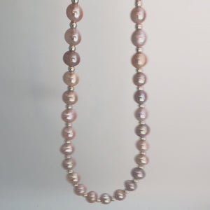 Video of a Pink freshwater pearl necklace with naturally varied blush and mauve tones and small silver plated spacer beads on a white background. 