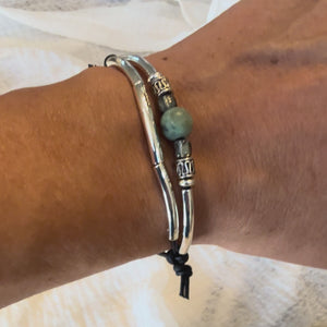 Video of adjustable bracelet with black leather, African turquoise and silver plated accents on a wrist.