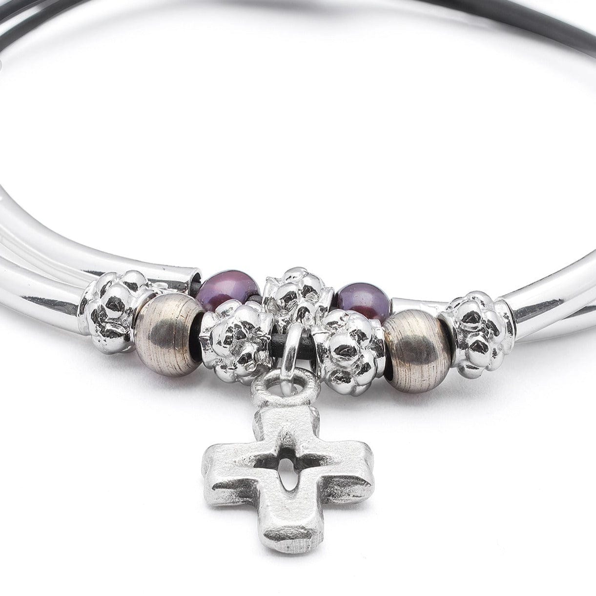 Close-up of a wrist wearing multiple bracelets with a patterned sleeve.
